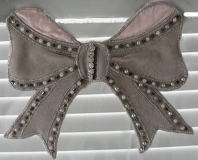 Rusetin ensimmäinen logo on valokuva haalean roosasta sametti rusetista, jossa reunoilla helmiä.